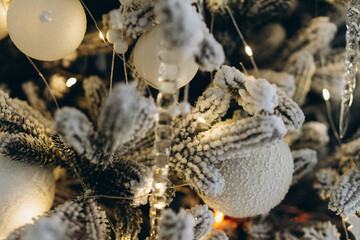 Christmas tree decorated with toys and garlands close-up, holidays location, selective focus, noise and grain in the photo