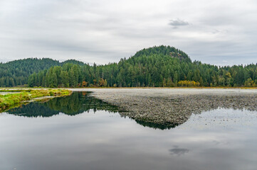 Beautiful view of forested mountains and a lake in MInnekhada Regional Park, Coquitlam, Canada