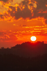 Fototapeta premium The glowing sun setting over mountains range.