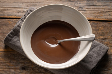 Melting chocolate in cup on dark background
