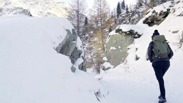 Ragazza che cammina nella neve in montagna