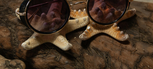 women's sunglasses lie on starfish, summer composition
