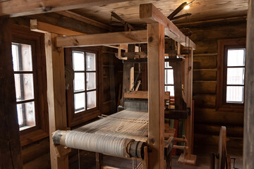 Ancient weaver loom with linen threads exposed in folk crafts museum in old wooden village...