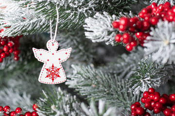 white Christmas angel on a tree. Wooden angel on the Christmas tree. festive background with christmas toy