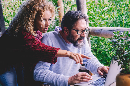 Adult couple use and look at display laptop worried and scared. Concept of man and woman online business activity reading bad news notification on computer