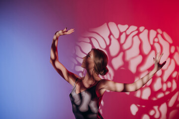 Naklejka premium beautiful girl in a dress, blonde hair, dancing on a colored background with a pattern
