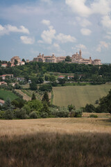 Fototapeta na wymiar Corinaldo, Ancona. Panorama estivo del borgo nel contesto rurale con il Santuario Diocesano di Santa Maria Goretti. 