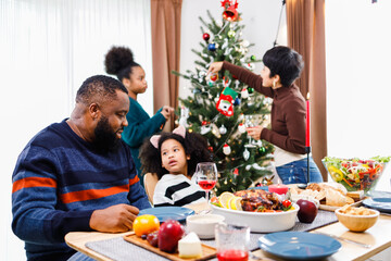 African American family. Merry Christmas. Happy family are having dinner at home. Celebration holiday and togetherness near Christmas tree.
