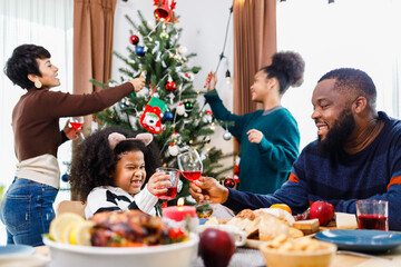 African American family. Merry Christmas. Happy family are having dinner at home. Celebration holiday and togetherness near Christmas tree.