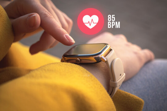 Close-up smart watch with heart rate icon, healthcare concept. Woman check the pusle with application