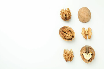 Walnuts with nutshell on white background, top view