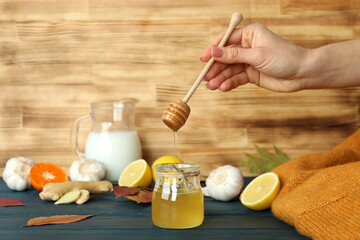 Concept of treatment colds with honey and garlic on  wooden table