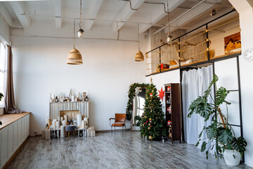 Interior shot. Two-storey room with large panoramic window, fireplace, decorated Christmas tree, preparations for the new year Modern apartment.