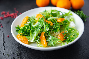 salad citrus lettuce, mix leaves, tangerine or orange meal snack on the table copy space food background rustic. top view keto or paleo diet veggie vegan or vegetarian food