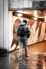 Back of man walking through gloomy underpass