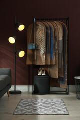 Garment bags with clothes hanging on rack in room
