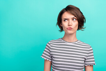 Photo of young attractive girl serious brainstorming think minded look empty space isolated over teal color background