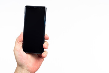 Cell phone hand. Phone with black screen on white background. Dark smartphone in man's hand. Someone demonstrates switched off cellphone. Place for text on gadget. Space for application on screen