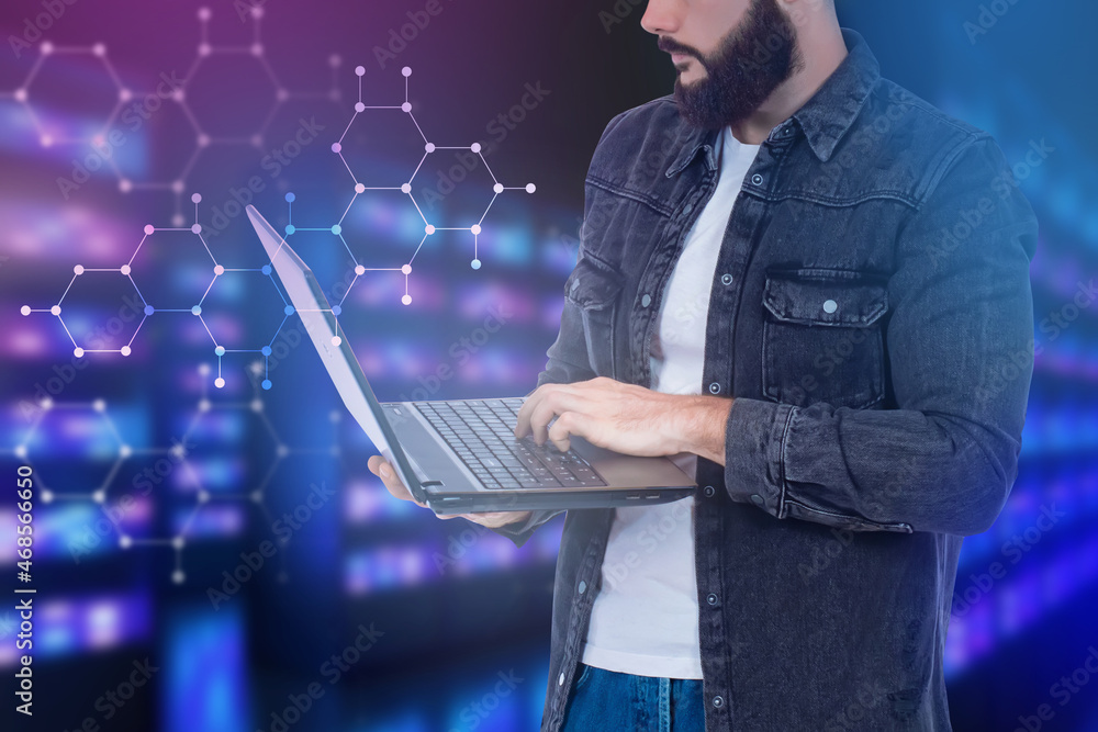 Poster a man stands with laptop in his hands. system administrator is typing something. guy on background i