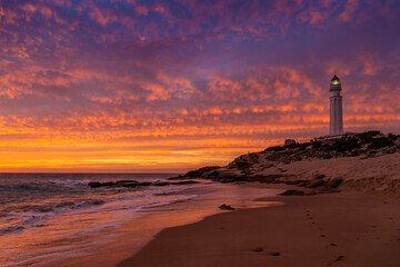 Atardecer de nubes rojas en la playa del faro de Trafalgar, Caños de Meca, provincia de Cádiz,...