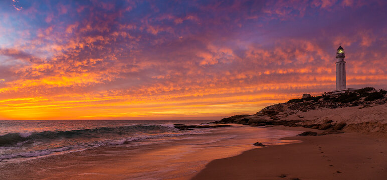 Red-clouded sunset panoramic view at Trafalgar Lighthouse beach, Ca&ntilde;os de Meca, Cadiz province, Andalusia, Spain