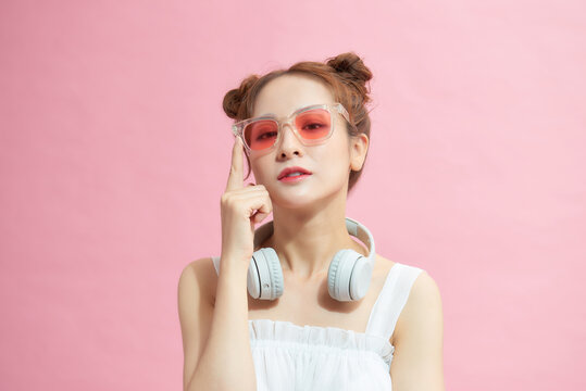 Photo of young excited  girl happy positive smile hands touch sunglass isolated over pink color background