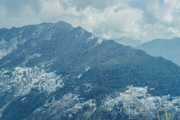 White clouds above the snow covered mountains of Parvati Valley as seen from the Bijli Mahadev Temple at Kullu in Himachal Pradesh, India