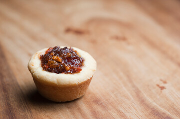 Single fruit mince tart on timber bench at Christmas