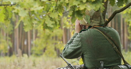 Hidden Re-enactor Dressed As German Wehrmacht Infantry Soldier In World War II Soldier Sitting In...