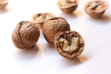Whole and cracked walnuts on white background, selective focus