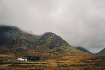 A beautiful cottage in front of the Buachaille Etive Mor in the mountains at Glencoe in Scotland wrapped with the thick fog.  © Mykola Romanovsky