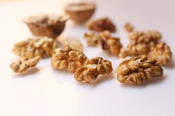 Whole and cracked walnuts on white background