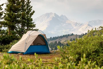 Fotobehang Tent tegen de achtergrond van bos en bergen. © Greg Hansen/Wirestock