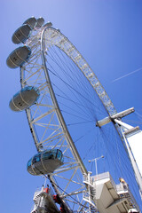 Vertical low-angle shot of the London Eye against the background of the blue sky. - obrazy, fototapety, plakaty