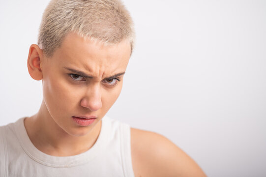Displeased young caucasian woman with short haircut on white background.