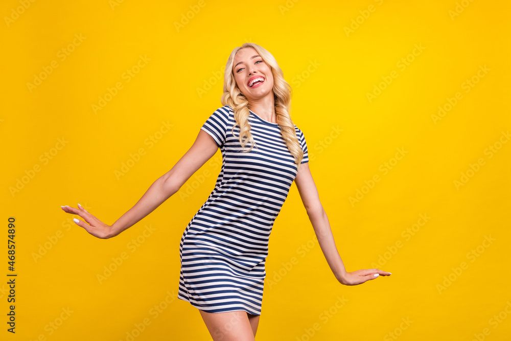 Poster portrait of attractive cheerful wavy-haired girl dancing having fun isolated over bright yellow colo