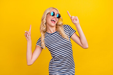 Portrait of attractive cheerful girl dancing having fun resting clubbing isolated over vibrant yellow color background