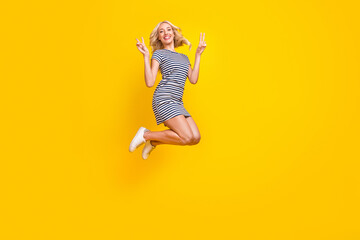 Fototapeta na wymiar Full length body size photo woman jumping up showing v-sign gesture isolated vibrant yellow color background