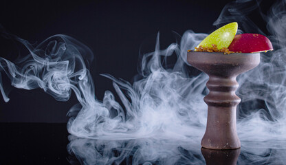 fruit hookah bowl with tobacco, two apple and smoke on black background