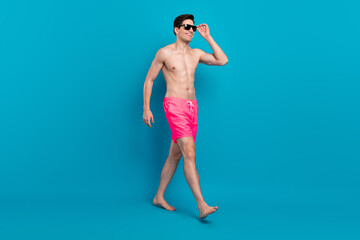 Full body profile side photo of young man happy positive smile go walk step wear sunglass vacation...
