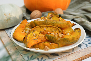 Plate of baked pumpkin with provencal herbs and walnuts. Seasonal autumn Thanksgiving food.