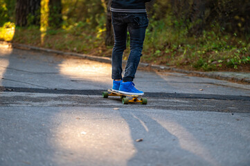 leisure activity, sportive lifestyle, young man riding skateboard, feet and skateboard, close-up
