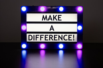 Lightbox with green lights in dark room with words - make a difference!