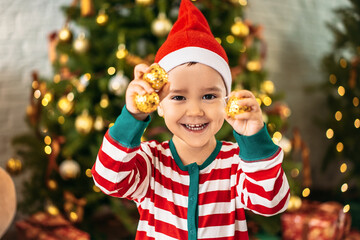 a little joyful boy with Christmas toys on the background of a Christmas tree. holiday concept