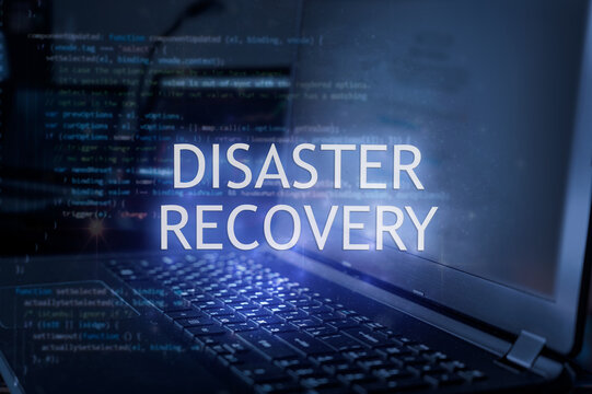 Disaster recovery inscription against laptop and code background. Technology concept.