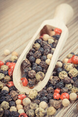 Colored pepper on wooden board as cooking spice