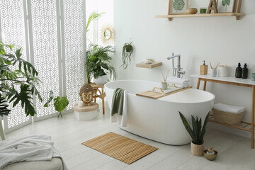 Stylish bathroom interior with modern tub, houseplants and beautiful decor. Home design - obrazy, fototapety, plakaty