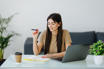 Young Woman freelancer hands with pen writing on notebook at home or office