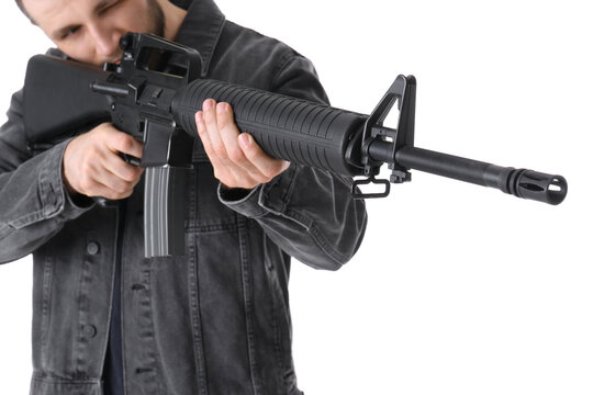 Assault gun. Man aiming rifle against white background, focus on barrel