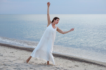Woman dancing in white dress near the sea © ottochka